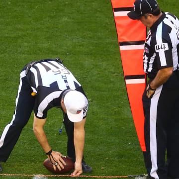 NFL referee Walt Anderson spots the ball after measuring with the chains during a game between the San Francisco 49ers and Arizona Cardinals.