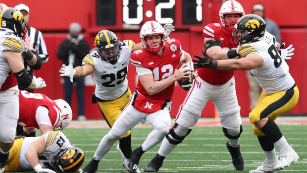 Nov 24, 2023; Lincoln, Nebraska, USA; Nebraska Cornhuskers quarterback Chubba Purdy (12) avoids a sack from Iowa Hawkeyes def