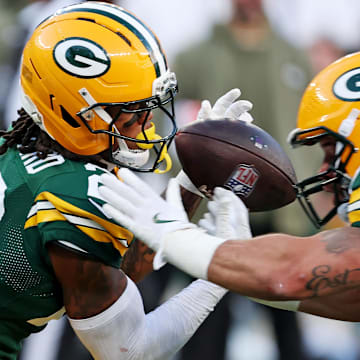 Green Bay Packers linebacker Isaiah McDuffie knocks the ball away from safety Javon Bullard as he is about to make an interception.