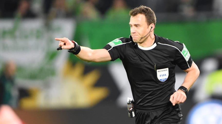 A referee points for a penalty.