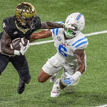 Sep 14, 2024; Winston-Salem, North Carolina, USA;  Wake Forest Demon Deacons running back Demond Claiborne (1) stiff arms Mississippi Rebels linebacker TJ Dottery (6) during the second half at Allegacy Federal Credit Union Stadium. Mandatory Credit: Jim Dedmon-Imagn Images