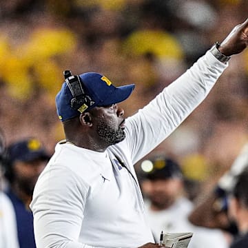 Michigan linebackers coach Brian Jean-Mary signals players before a play against New Mexico during the first half at Michigan Stadium in Ann Arbor on Saturday, August 30, 2025.