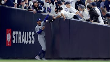 Oct 29, 2024; New York, New York, USA; Los Angeles Dodgers shortstop Mookie Betts (50) makes a catch in foul territory as a New York Yankees fan interferes during the first inning in game four of the 2024 MLB World Series at Yankee Stadium. Mandatory Credit: Brad Penner-Imagn Images