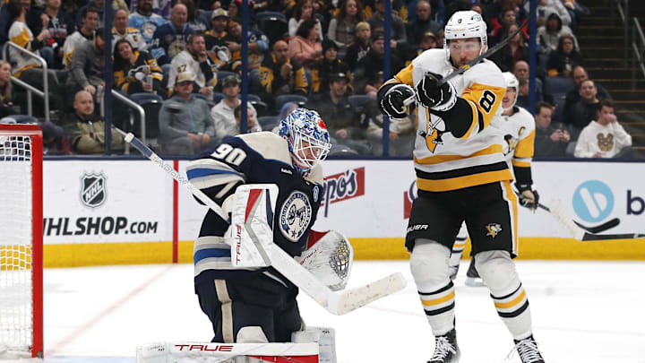 Nov 15, 2024; Columbus, Ohio, USA; Pittsburgh Penguins left wing Michael Bunting (8) tips the puck over Columbus Blue Jackets goalie Elvis Merzlikins (90) during the third period at Nationwide Arena. Mandatory Credit: Russell LaBounty-Imagn Images
