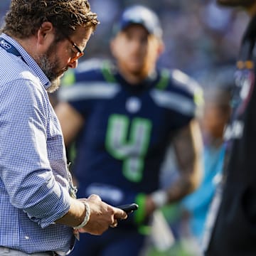 Oct 6, 2024; Seattle, Washington, USA; Seattle Seahawks general manager John Schneider looks at his phone during the fourth quarter against the New York Giants at Lumen Field. 