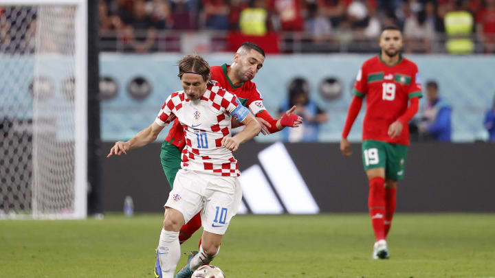 Dec 17, 2022; Doha, Qatar; Croatia midfielder Luka Modric (10) kicks the ball past Morocco midfielder Hakim Ziyech (7) in the first half for the third-place match during the 2022 World Cup at Khalifa International Stadium.