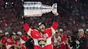 Jun 17, 2025; Sunrise, Florida, USA; Florida Panthers left wing Matthew Tkachuk (19) hoist the Stanley Cup after game six of the 2025 Stanley Cup Final against the Edmonton Oilers at Amerant Bank Arena. Mandatory Credit: Jim Rassol-Imagn Images