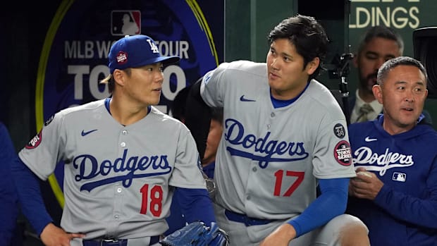 Los Angeles Dodgers starting pitcher Yoshinobu Yamamoto (18) and designated hitter Shohei Ohtani (17) stand in the dugout.