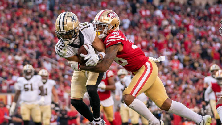 November 27, 2022; Santa Clara, California, USA; New Orleans Saints wide receiver Chris Olave (12) is tackled by San Francisco 49ers cornerback Deommodore Lenoir (38) during the fourth quarter at Levi's Stadium. Mandatory Credit: Kyle Terada-USA TODAY Sports