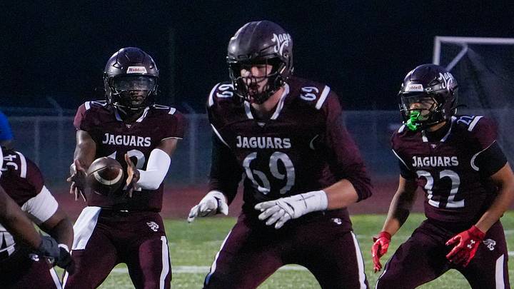 Appoquinimink quarterback Desai Drummond takes a snap in front of lineman Layton von Brandt (69) as running back Jayden Triplett works in the backfield in the first quarter in the Jaguars' 34-20 win against Dover at Appoquinimink, Sept 5, 2025.