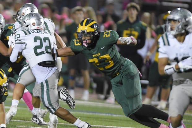 Marco Jones (23), the Bay Area's top recruit for 2025 from San Ramon Valley, takes down De La Salle's Derrick Blanche Jr.