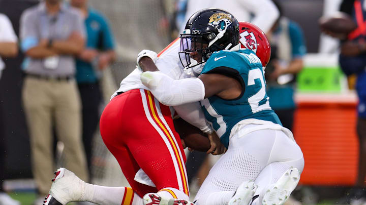 Aug 10, 2024; Jacksonville, Florida, USA; Jacksonville Jaguars safety Daniel Thomas (20) brings down Kansas City Chiefs quarterback Carson Wentz (11) in the second quarter during preseason at EverBank Stadium. Mandatory Credit: Nathan Ray Seebeck-Imagn Images