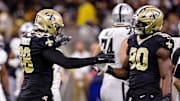 Oct 30, 2022; New Orleans, Louisiana, USA;  New Orleans Saints defensive end Payton Turner (98) and New Orleans Saints defensive end Tanoh Kpassagnon (90) react to sacking Las Vegas Raiders quarterback Jarrett Stidham (3) during the second half at Caesars Superdome. Mandatory Credit: Stephen Lew-Imagn Images
