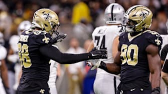 Oct 30, 2022; New Orleans, Louisiana, USA;  New Orleans Saints defensive end Payton Turner (98) and New Orleans Saints defensive end Tanoh Kpassagnon (90) react to sacking Las Vegas Raiders quarterback Jarrett Stidham (3) during the second half at Caesars Superdome. Mandatory Credit: Stephen Lew-Imagn Images