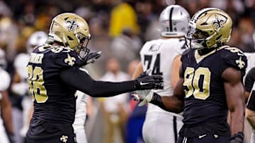 Oct 30, 2022; New Orleans, Louisiana, USA;  New Orleans Saints defensive end Payton Turner (98) and New Orleans Saints defensive end Tanoh Kpassagnon (90) react to sacking Las Vegas Raiders quarterback Jarrett Stidham (3) during the second half at Caesars Superdome. Mandatory Credit: Stephen Lew-Imagn Images