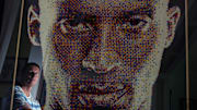 John Darovitz is reflected in his pointillist art of a likeness of Kobe Bryant from his home in Daytona Beach, Monday, May 6, 2024.