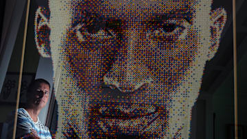 John Darovitz is reflected in his pointillist art of a likeness of Kobe Bryant from his home in Daytona Beach, Monday, May 6, 2024.