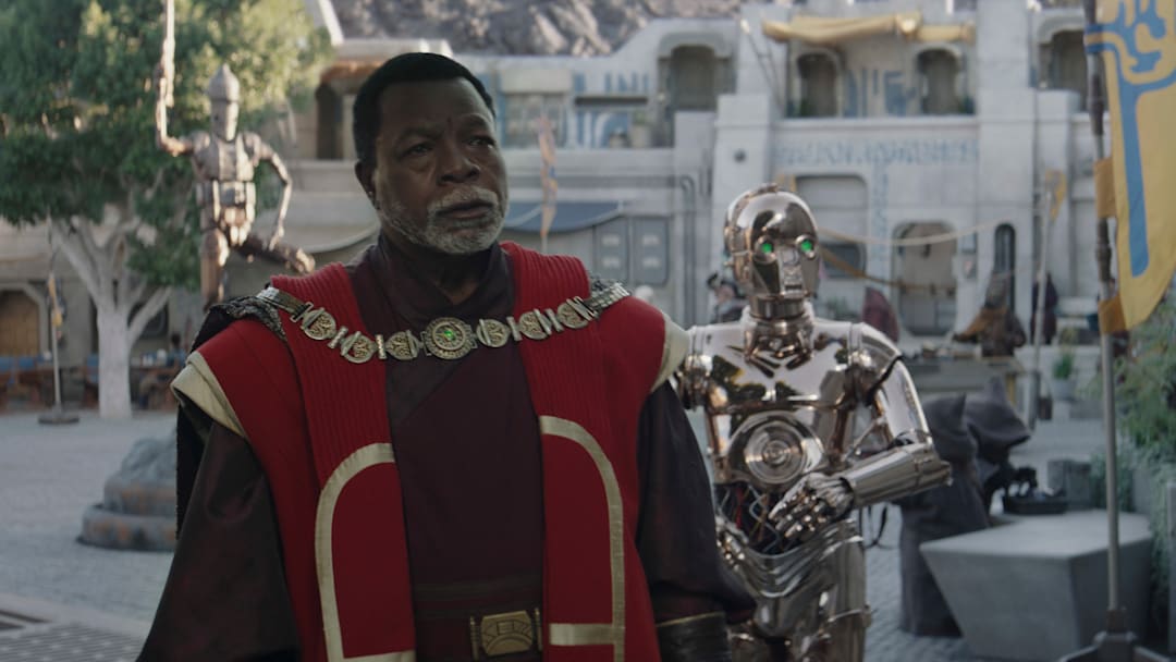 (L-R): Greef Karga (Carl Weathers) and Nevarro copper droid (Chris Bartlett) in Lucasfilm's THE MANDALORIAN, season three, exclusively on Disney+. ©2023 Lucasfilm Ltd. & TM. All Rights Reserved.