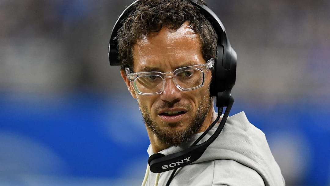 Aug 16, 2025; Detroit, Michigan, USA; Former Miami Dolphins head coach Mike McDaniels looks on from the sidelines in their game against the Detroit Lions in the first quarter at Ford Field.