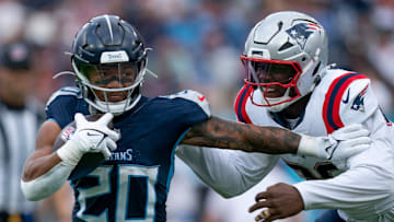 Tennessee Titans running back Tony Pollard (20) holds off New England Patriots defensive end Keion White (99) during their game at Nissan Stadium in Nashville, Tenn., Sunday, Nov. 3, 2024. White brought down Pollard, but was called for a horse-collar tackle penalty.