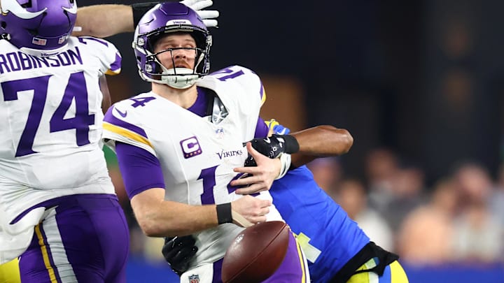 Jan 13, 2025; Glendale, AZ, USA; Minnesota Vikings quarterback Sam Darnold (14) is sacked by Los Angeles Rams cornerback Ahkello Witherspoon (4) causing a fumble during the first half in an NFC wild card game at State Farm Stadium. Mandatory Credit: Mark J. Rebilas-Imagn Images