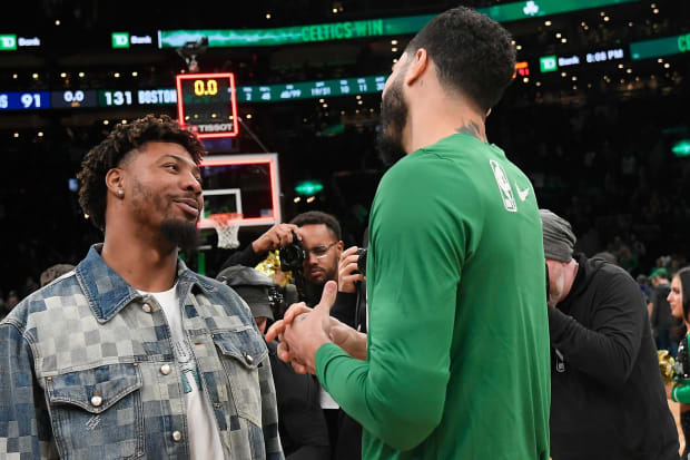 Memphis Grizzlies guard Marcus Smart (36) talks to Boston Celtics forward Jayson Tatum (right) after a game at TD Garden.