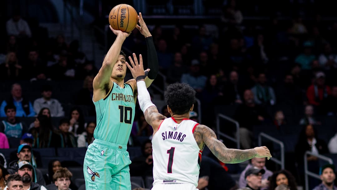 Jan 24, 2025; Charlotte, North Carolina, USA; Charlotte Hornets guard Josh Green (10) shoots over Portland Trail Blazers guard Anfernee Simons (1) during the first quarter at Spectrum Center. Mandatory Credit: Scott Kinser-Imagn Images
