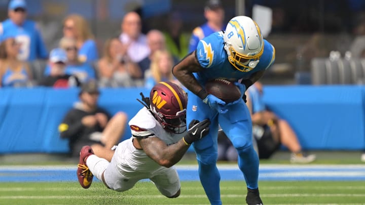 Oct 5, 2025; Inglewood, California, USA;  Los Angeles Chargers running back Omarion Hampton (8) makes a catch against Washington Commanders linebacker Frankie Luvu (4) in the first half at SoFi Stadium. Mandatory Credit: Jayne Kamin-Oncea-Imagn Images