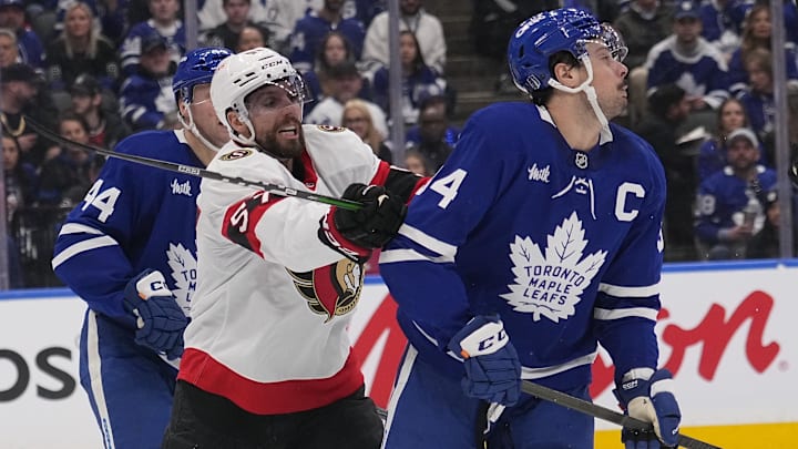 Apr 20, 2025; Toronto, Ontario, CAN; Ottawa Senators forward David Perron (57) checks Toronto Maple Leafs forward Auston Matthews (34) during the second period of game one of the first round of the 2025 Stanley Cup Playoffs at Scotiabank Arena. Mandatory Credit: John E. Sokolowski-Imagn Images