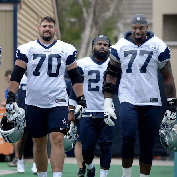 Dallas Cowboys stars Zack Martin and Tyron Smith head out to the field during training camp.