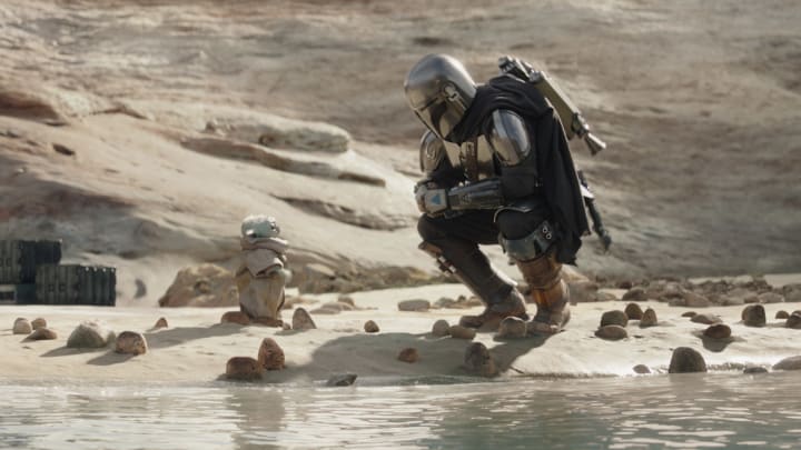 (L-R): Grogu and Din Djarin (Pedro Pascal) with stone crabs in Lucasfilm's THE MANDALORIAN, season three, exclusively on Disney+. ©2023 Lucasfilm Ltd. & TM. All Rights Reserved.