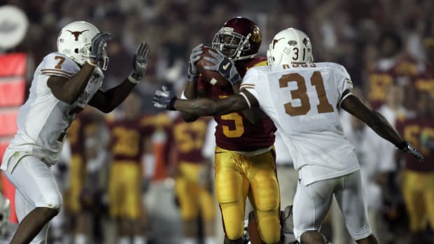 USC running back Reggie Bush (#5) is surrounded by Texas defenders Michael Huff (#7), Drew Kelson (#4) and Aaron Ross (#31) j