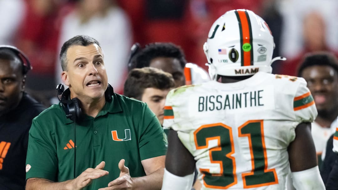 Jan 19, 2026; Miami Gardens, FL, USA; Miami Hurricanes head coach Mario Cristobal with linebacker Wesley Bissainthe (31) against the Indiana Hoosiers during the College Football Playoff National Championship game at Hard Rock Stadium. Mandatory Credit: Mark J. Rebilas-Imagn Images