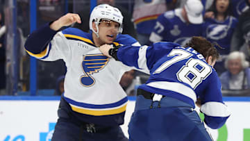 Dec 19, 2024; Tampa, Florida, USA; St. Louis Blues center Brayden Schenn (10) and Tampa Bay Lightning defenseman Emil Lilleberg (78) fight during the second period at Amalie Arena. Mandatory Credit: Kim Klement Neitzel-Imagn Images
