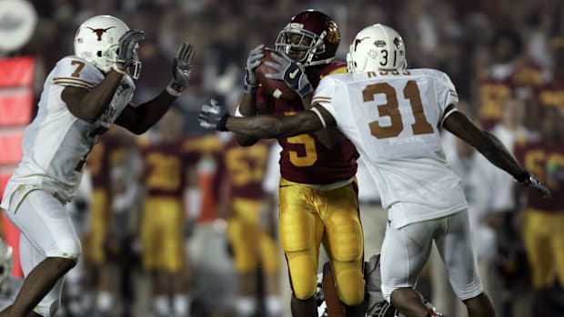 USC running back Reggie Bush (#5) is surrounded by Texas defenders Michael Huff (#7), Drew Kelson (#4) and Aaron Ross (#31) 