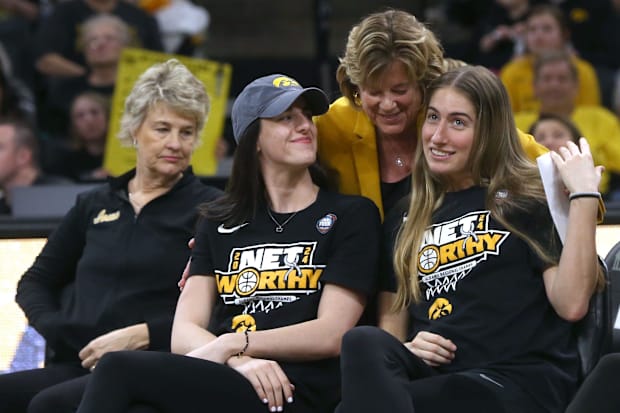 Iowa president Barbara Wilson hugs Caitlin Clark and Kate Martin.