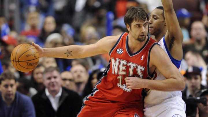 Jan 25, 2012; Philadelphia, PA, USA; New Jersey Nets center Mehmet Okur (13) is defended by Philadelphia 76ers guard Evan Turner (12) during the third quarter at the Wells Fargo Center. The Nets defeated the Sixers 97-90 in overtime. Mandatory Credit: Howard Smith-USA TODAY Sports