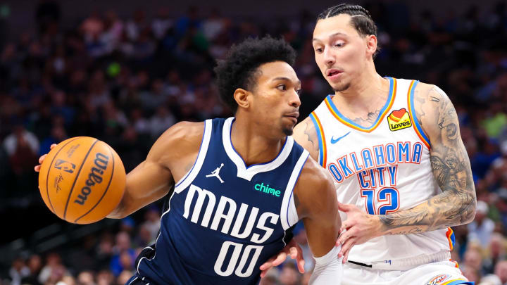 Feb 10, 2024; Dallas, Texas, USA; Dallas Mavericks guard Brandon Williams (00) drives to the basket as Oklahoma City Thunder forward Lindy Waters III (12) defends during the second half at American Airlines Center. Mandatory Credit: Kevin Jairaj-USA TODAY Sports