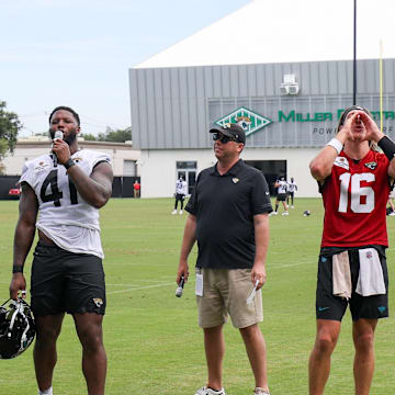 Jul 26, 2024; Jacksonville, FL, USA;  Jacksonville Jaguars quarterback Trevor Lawrence (16) and linebacker Josh Hines-Allen (41) speak to fans during training camp at Miller Electric Center. Mandatory Credit: Nathan Ray Seebeck-Imagn Images