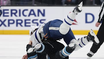 Mar 10, 2025; Salt Lake City, Utah, USA; Utah Hockey Club defenseman Michael Kesselring (7) and Toronto Maple Leafs defenseman Simon Benoit (2) fight during the second period at Delta Center. Mandatory Credit: Rob Gray-Imagn Images