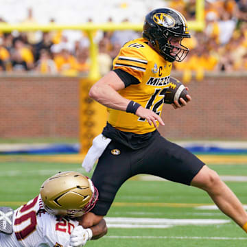 Sep 14, 2024; Columbia, Missouri, USA; Missouri Tigers quarterback Brady Cook (12) runs the ball as Boston College Eagles defensive back KP Price (20) makes the tackle during the first half at Faurot Field at Memorial Stadium. Mandatory Credit: Denny Medley-Imagn Images