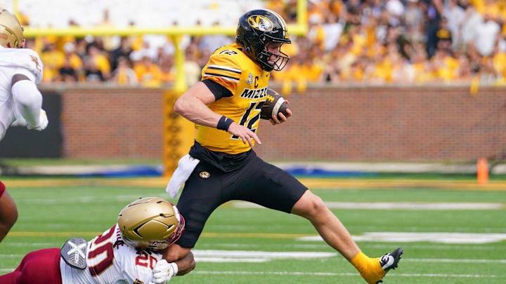 Sep 14, 2024; Columbia, Missouri, USA; Missouri Tigers quarterback Brady Cook (12) runs the ball as Boston College Eagles defensive back KP Price (20) makes the tackle during the first half at Faurot Field at Memorial Stadium. Mandatory Credit: Denny Medley-Imagn Images