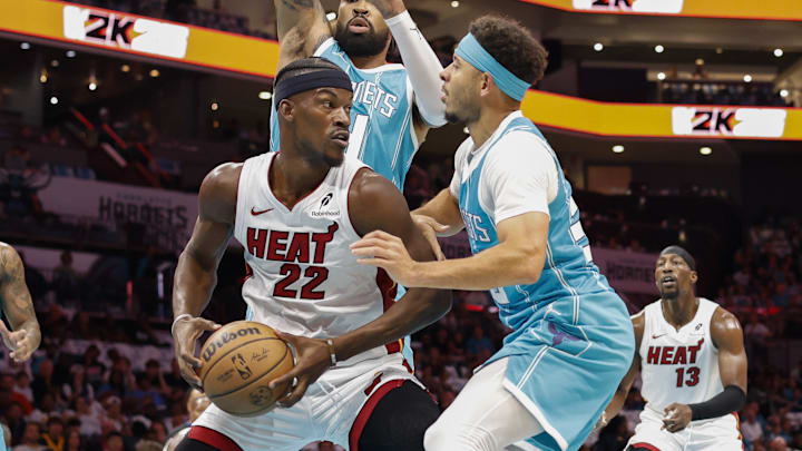 Oct 26, 2024; Charlotte, North Carolina, USA; Miami Heat forward Jimmy Butler (22) looks to pass against Charlotte Hornets guard Seth Curry (30) and center Nick Richards (4) during the first quarter at Spectrum Center. Mandatory Credit: Nell Redmond-Imagn Images