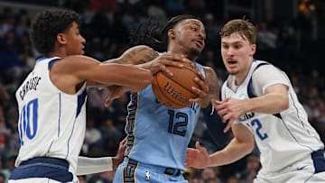 Nov 7, 2025; Memphis, Tennessee, USA; Memphis Grizzlies guard Ja Morant (12) drives to the basket against Dallas Mavericks guard Max Christie (00) and forward Cooper Flagg (32) during the second quarter at FedExForum. Mandatory Credit: Petre Thomas-Imagn Images