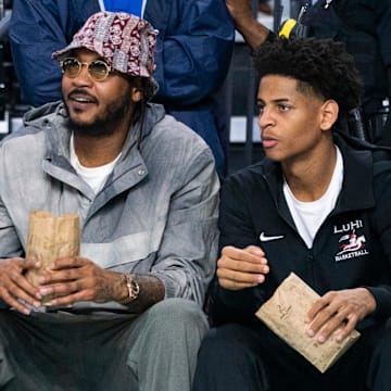 Carmelo Anthony and his son, Kiyan, watch the Don Bosco Prep Ironmen compete against the McEachern Indians