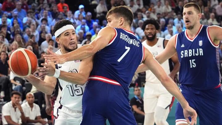 Aug 8, 2024; Paris, France; United States guard Devin Booker (15) passes the ball around Serbia shooting guard Bogdan Bogdanovic (7) during the first half in a men's basketball semifinal game during the Paris 2024 Olympic Summer Games at Accor Arena. Mandatory Credit: Rob Schumacher-USA TODAY Sports