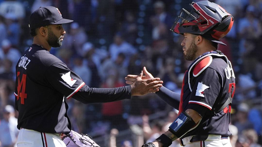 Jun 14, 2026; Minneapolis, Minnesota, USA; Minnesota Twins relief pitcher Yoendrys Gomez (94) and catcher Victor Caratini (37) celebrate the win over the St. Louis Cardinals after the game at Target Field.