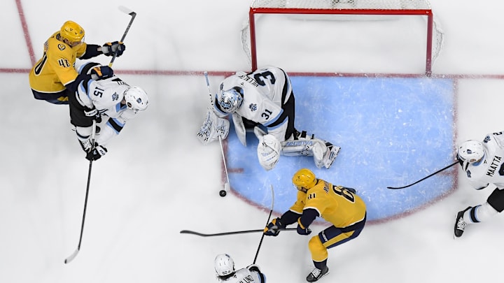 Apr 14, 2025; Nashville, Tennessee, USA;  Utah Hockey Club goaltender Matt Villalta (31) blocks a shot by Nashville Predators center Jonathan Marchessault (81) during the second period at Bridgestone Arena. Mandatory Credit: Steve Roberts-Imagn Images