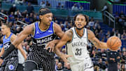Nov 14, 2025; Orlando, Florida, USA; Brooklyn Nets center Nic Claxton (33) drives to the basket around Orlando Magic center Wendell Carter Jr. (34) during the first quarter at Kia Center. Mandatory Credit: Mike Watters-Imagn Images