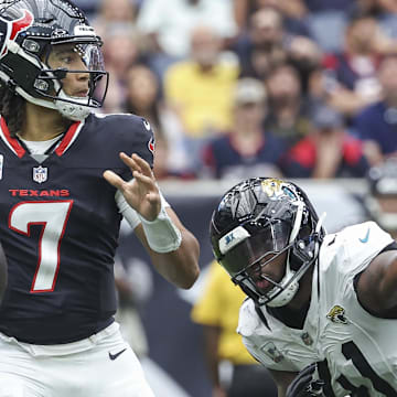Sep 29, 2024; Houston, Texas, USA; Houston Texans quarterback C.J. Stroud (7) looks for an open receiver as Jacksonville Jaguars defensive end Josh Hines-Allen (41) applies defensive pressure during the second quarter at NRG Stadium. Mandatory Credit: Troy Taormina-Imagn Images